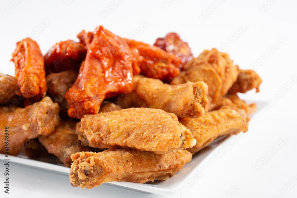 A view of a plate of a chicken wings sampler, featuring flavors as buffalo and BBQ sauce. A view of a plate of a chicken wings sampler, featuring flavors as buffalo and BBQ sauce.