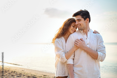 Happy young couple two friend family man woman in casual clothes hug girlfriend put head on boyfriend shoulder at sunrise over sea sand beach ocean outdoor exotic seaside in summer day sunset evening