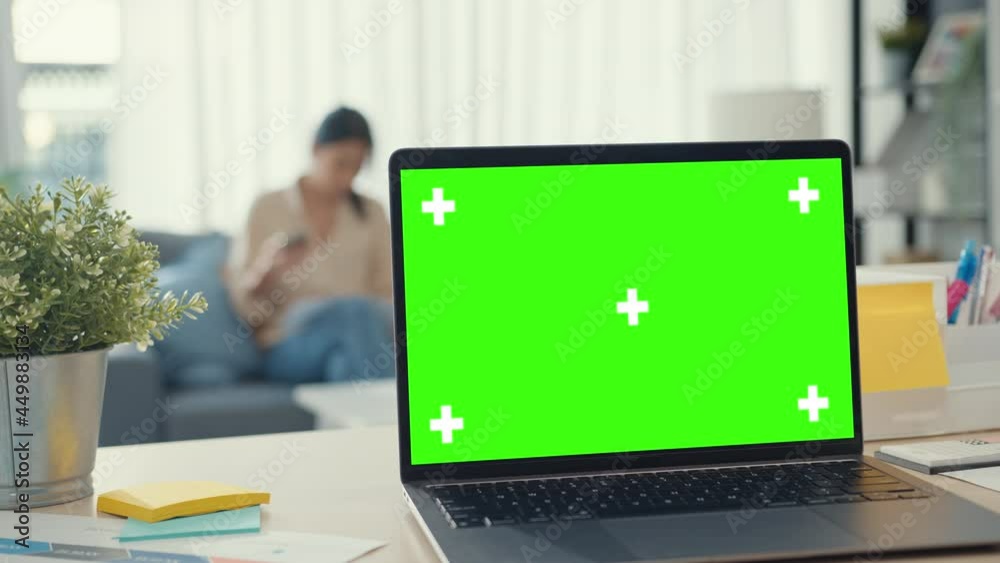 Computer laptop with blank green screen mock up display for advertising text on desk in living room at modern house. Chroma key technology, Marketing design concept. Computer laptop with blank green screen mock up display for advertising text on desk in living room at modern house. Chroma key technology, Marketing design concept.