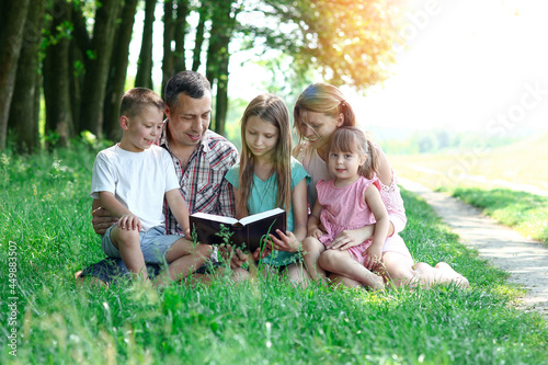 young family with children reading the Bible in nature