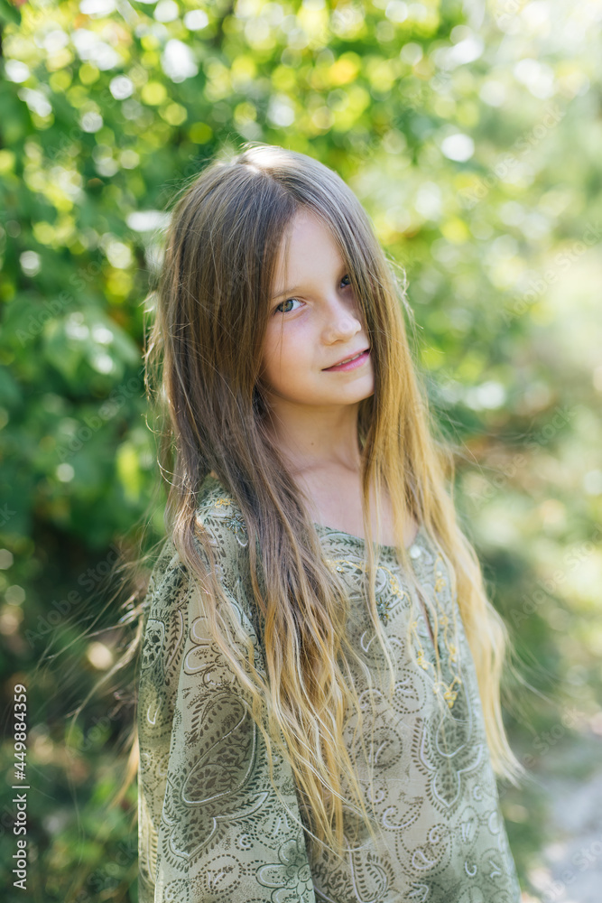 Naklejka premium beautiful attractive stylish girl in a green dress, with long hair romantic mood, posing in summer fashion style, natural look