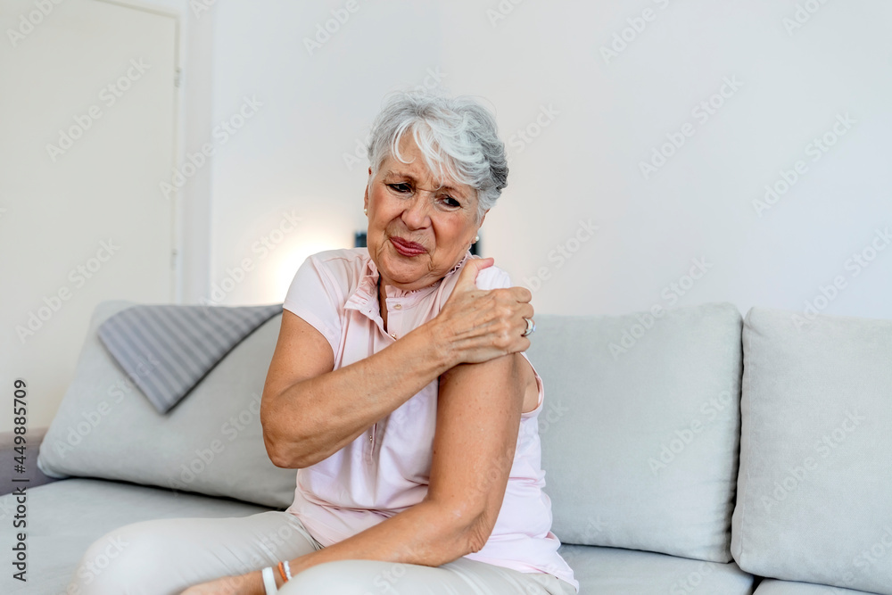 Woman with shoulder pain. Woman grimaces at the pain in her shoulders. Upset senior lady feel sudden shoulder pain, muscles ache tension injury. Grandma touching shoulder have osteoarthritis arthritis Woman with shoulder pain. Woman grimaces at the pain in her shoulders. Upset senior lady feel sudden shoulder pain, muscles ache tension injury. Grandma touching shoulder have osteoarthritis arthritis
