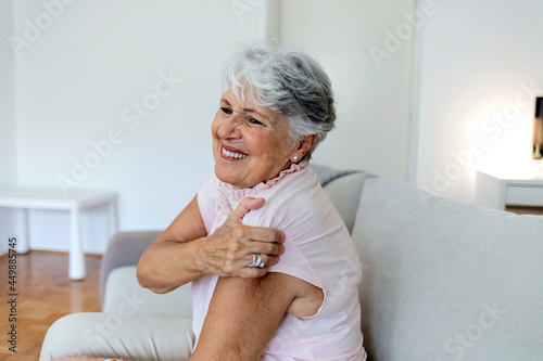 Photo of a aging lady is feeling ache in her body. Senior lady is demonstrating suffering from ache. Elderly woman suffering from pain in shoulder at home. Elderly woman shoulder pain, osteochondrosis