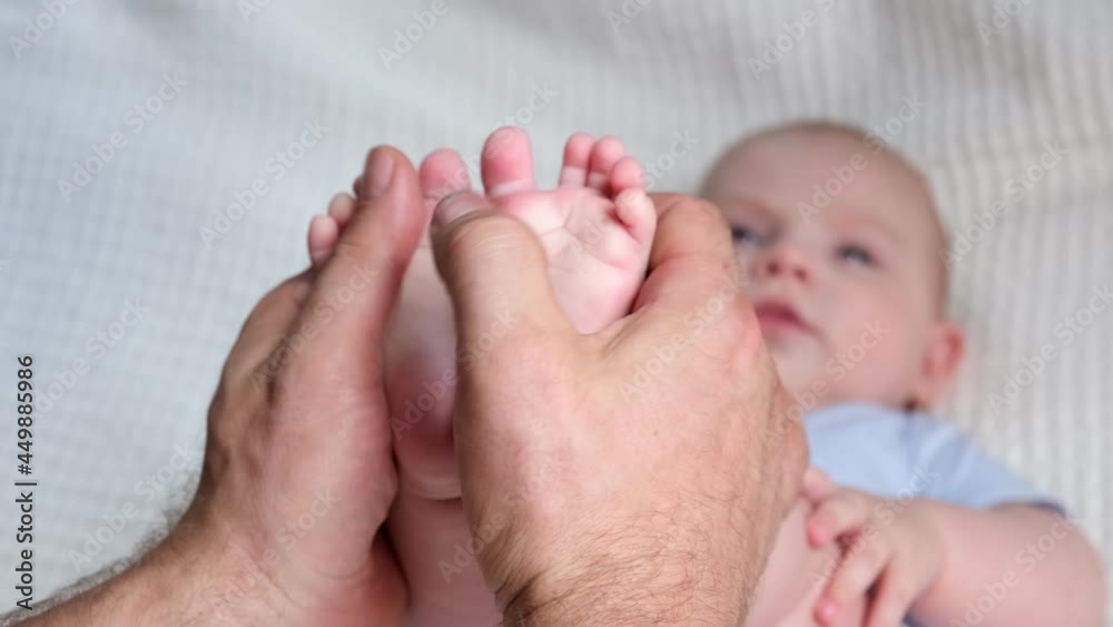 Father holding Baby Feet in Hands. Legs Newborn in male parents Hand. Small children's Feet in the Father's Palm. Close-up. Little Toes of Child and Man Hands of Happy Parent. Father's Day Holiday. Father holding Baby Feet in Hands. Legs Newborn in male parents Hand. Small children's Feet in the Father's Palm. Close-up. Little Toes of Child and Man Hands of Happy Parent. Father's Day Holiday.