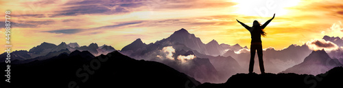 Frau mit ausgebreiteten Armen auf einem Berggipfel