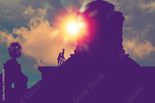 silhouette of two person with sunlight step on stairs to the top of a sacred ancient temple for make a pilgrimage