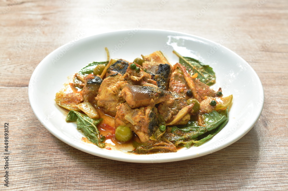 spicy slice stingray fish with eggplant and basil leaf in curry sauce on plate spicy slice stingray fish with eggplant and basil leaf in curry sauce on plate