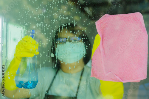 woman spraying and wiping glass photo