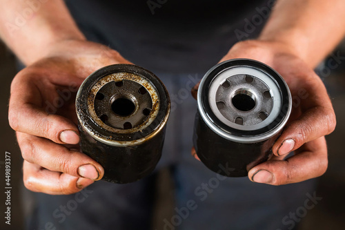  auto mechanic holds a new and used oil filter.