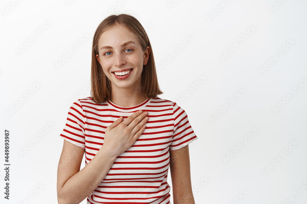 Thank you. Smiling young woman, student hold hand on chest and looking grateful, appreciate help, thanking, standing against white background, express gratitude, white background Thank you. Smiling young woman, student hold hand on chest and looking grateful, appreciate help, thanking, standing against white background, express gratitude, white background