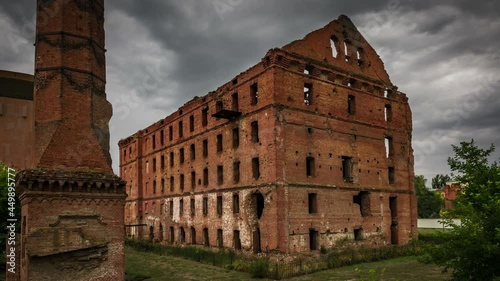 Old destroyed building and flying storm clouds photo