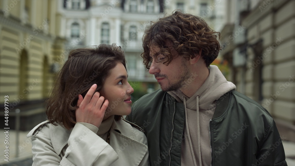 Happy couple looking eyes to eyes on urban street. Man kissing woman forehead. Happy couple looking eyes to eyes on urban street. Man kissing woman forehead.
