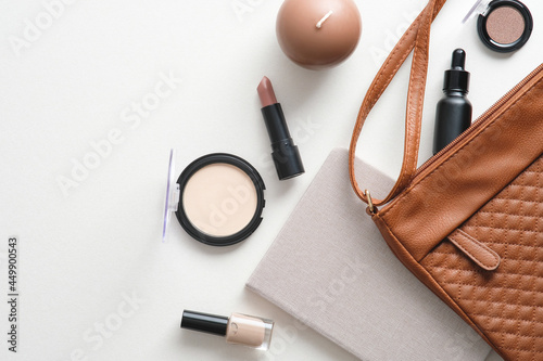 Cosmetic pouch with makeup accessories on white background. Flat lay, top view, overhead.