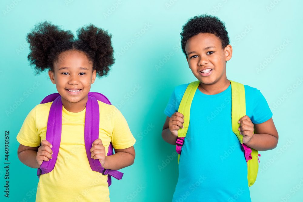 Portrait of two nice cheerful friends friendship going back to primary school isolated over bright teal turquoise color background Portrait of two nice cheerful friends friendship going back to primary school isolated over bright teal turquoise color background