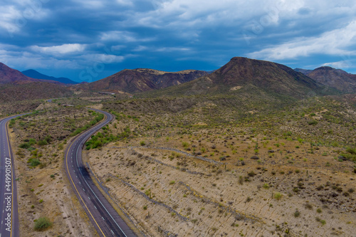 Dramatic clouds over the mountains are a desert cactus mountain landscape near the highway in Arizona
