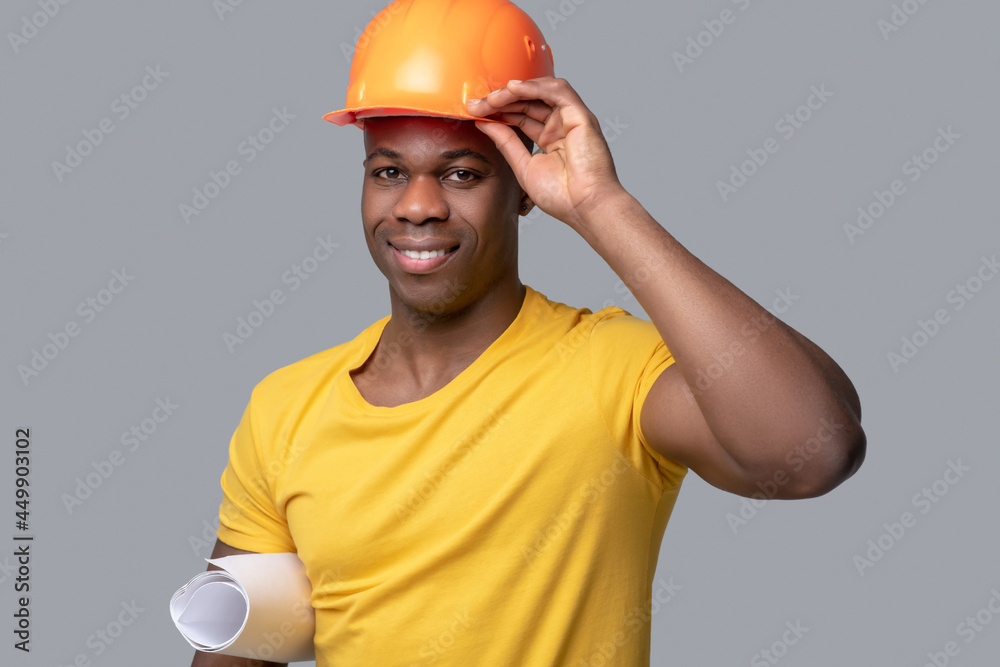 A dark-skinned construction engineer in a protective hemlet A dark-skinned construction engineer in a protective hemlet