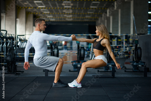 Sportive couple doing push-ups, training in gym