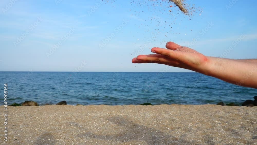 A man throw sand against the background of the sky and the sea. Slow motion. A man throw sand against the background of the sky and the sea. Slow motion.