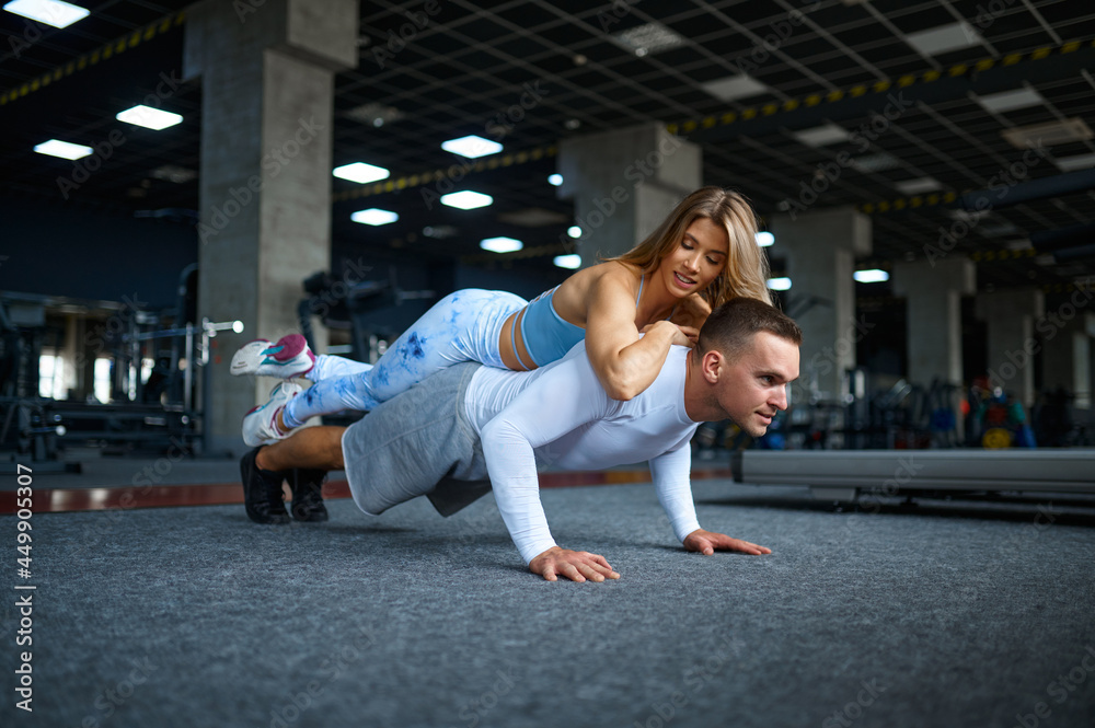 Couple doing push-ups, fitness training in gym