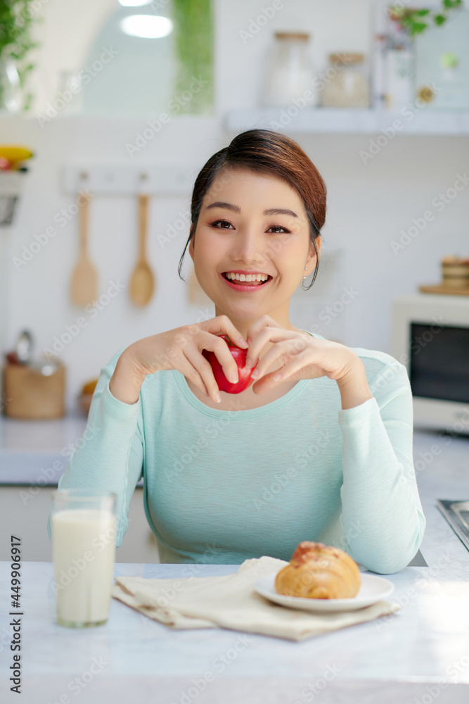 Beautiful young woman having breakfast in kitchen Beautiful young woman having breakfast in kitchen