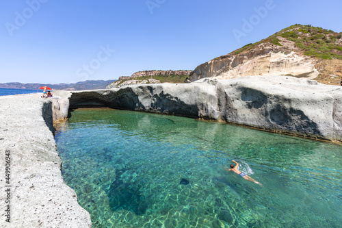Cane Malu, a man swims in the beautiful natural pool carved into the rock on the west coast of Sardinia, Bosa, Oristano, Italy, Europe photo