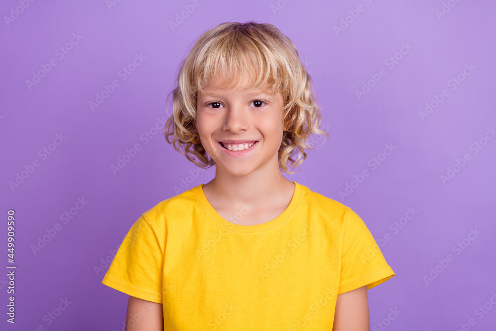 Photo of young cheerful positive boy smile good mood wear yellow t-shirt isolated on violet color background Photo of young cheerful positive boy smile good mood wear yellow t-shirt isolated on violet color background
