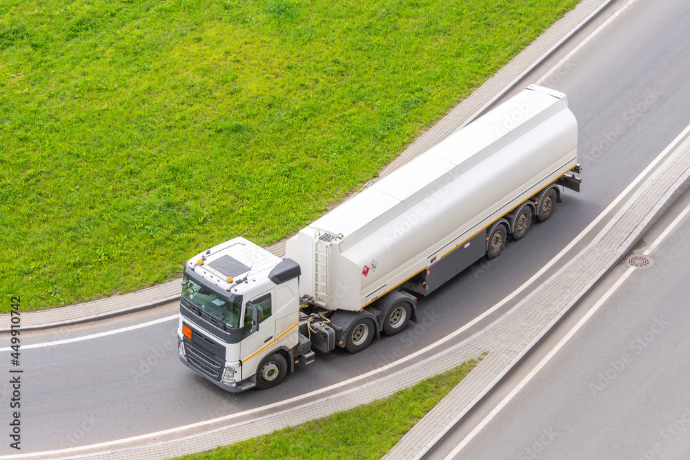 Truck with tank trailer and fuel turns on city highway, aerial view. Truck with tank trailer and fuel turns on city highway, aerial view.
