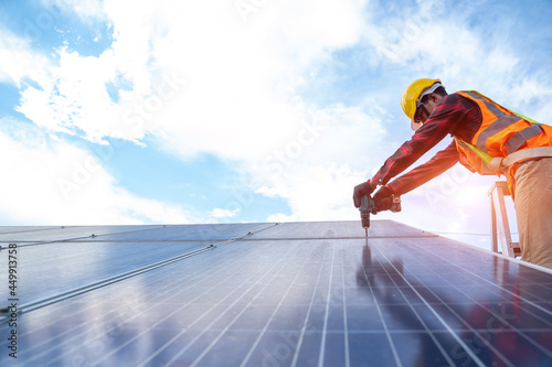 Solar panel technician with drill installing and maintenance solar panels on roof at solar power plant,Solar panel,Alternative electricity source.