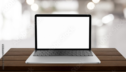 Laptop with blank screen on table with blurred restaurant background