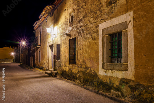 Spanish village street at night with old stone houses.