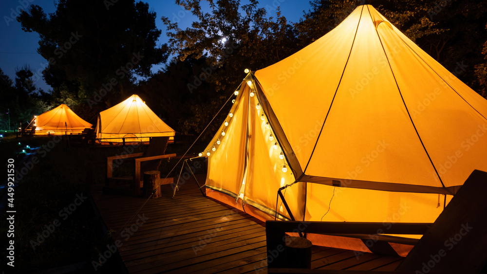 Glamping at night, few glowing tents
