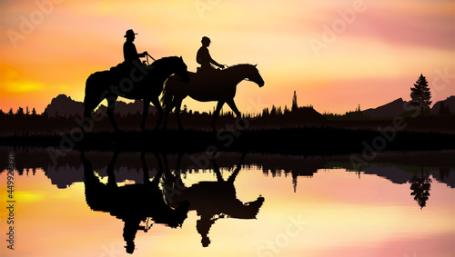 Cowboys couple on horseback at sunset