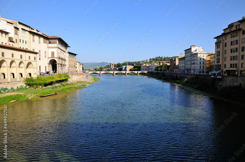 View of the buildings on the river Arno bank and Ponte alle Grazie from the Old Bridge (Ponte Vecchio). Florence, Italy.