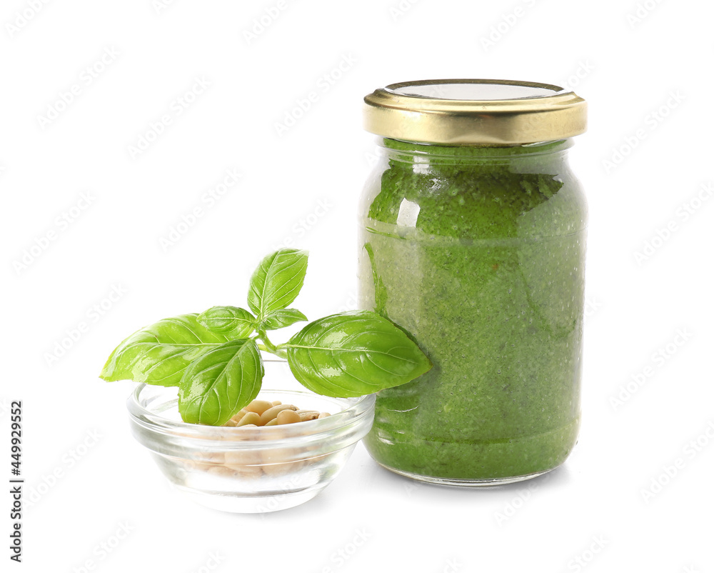 Jar with fresh pesto sauce and ingredients on white background Jar with fresh pesto sauce and ingredients on white background