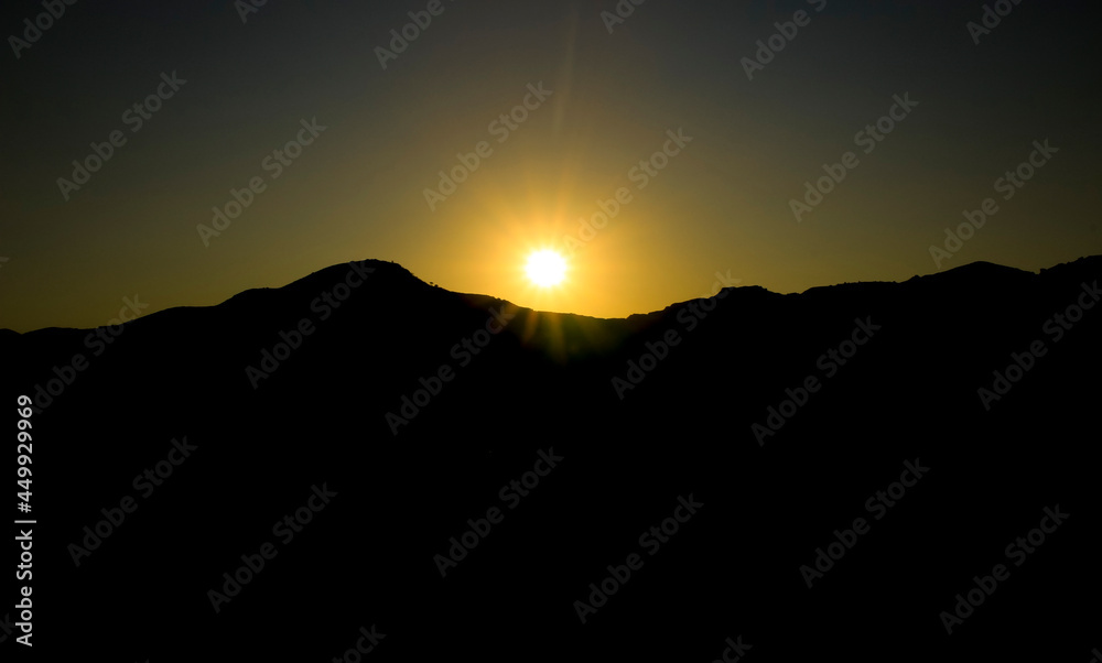 Sun setting behind the mountains at sunset