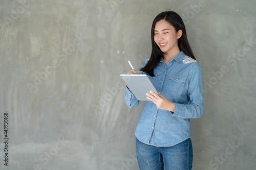 Young Asian businesswoman working online on tablet and rejoicing © Worranan