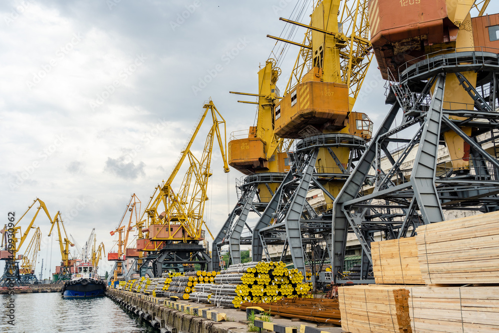 Metal pipes and stacks of timber ready for shipment in sea port in Ukraine Metal pipes and stacks of timber ready for shipment in sea port in Ukraine