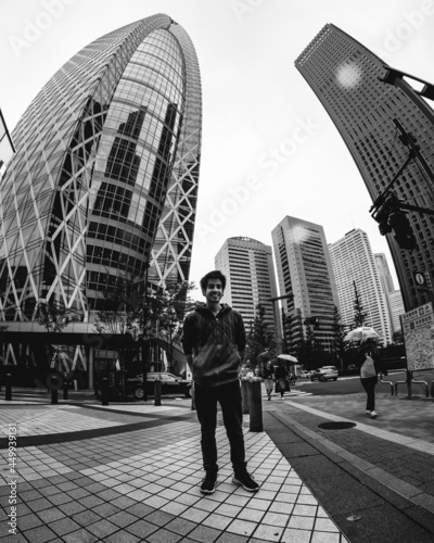 Canvas Print Young traveler guy, skyscrapers, cars and skyline from the ground level at Shinj