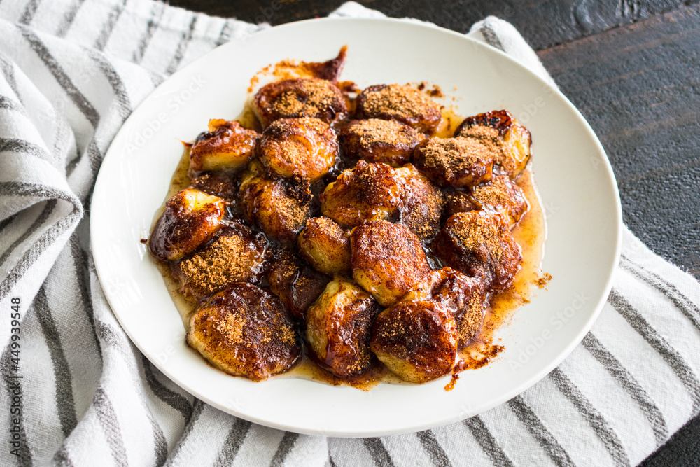 Pan Fried Cinnamon Bananas on a White Plate: Sliced banana that has bee fried in a mixture of cinnamon, sugar, and nutmeg Pan Fried Cinnamon Bananas on a White Plate: Sliced banana that has bee fried in a mixture of cinnamon, sugar, and nutmeg
