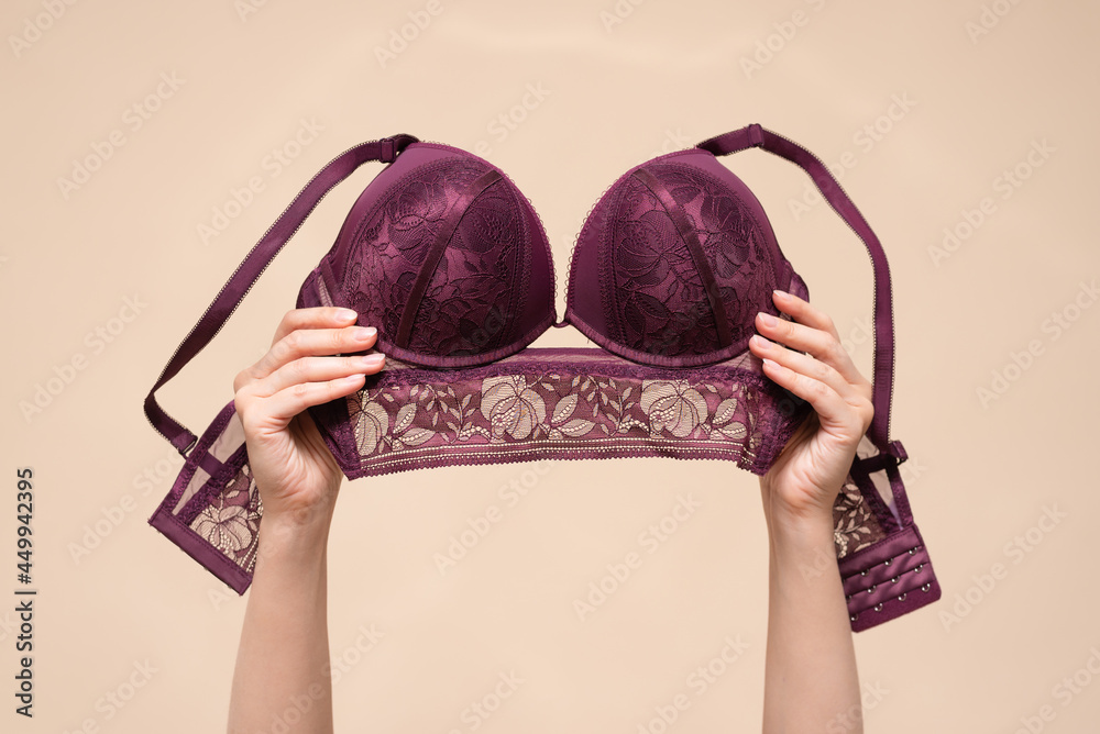 Woman is showing a new bra in the hand above her head. Choosing a new bra  concept. Stock Photo