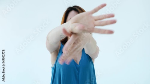 Adorable young girl in blue dress dancing with her hands alone in white studio backgrounds. Concept of difficulty in making decisions, the transience of time, beauty eternity
