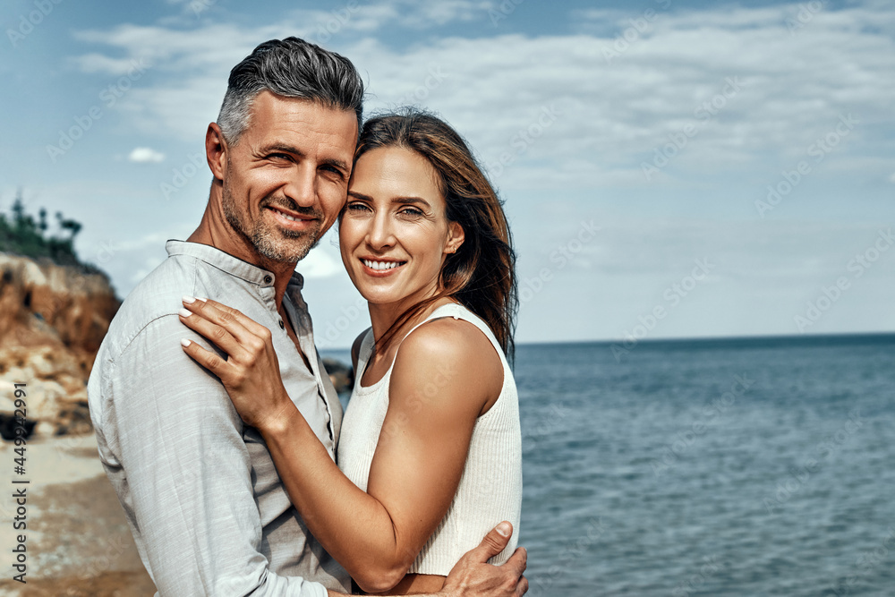 Happy middle aged couple laughing and hugging on the beach. Happy middle aged couple laughing and hugging on the beach.