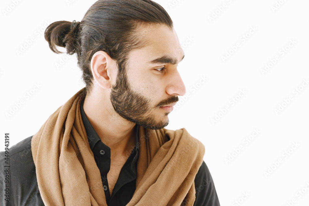 Young muslim man posing casually over white wall. Studio, isolated.