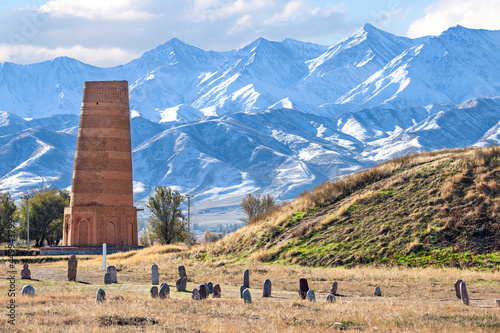 Burana tower which is an old and large minaret in the ruins of the ancient site of Balasagun with tombstones known as Balbas in the foreground, Kyrgyz photo