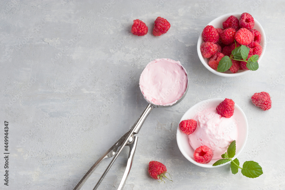 Delicious and romantic dessert. A ball of homemade raspberry walrus with fresh raspberries and mint in a white cup on a light background. Top view. Copy space.