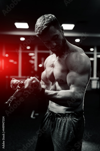 Athlete strong sporty bodybuilder. Handsome muscular man posing in the gym. © Vadim