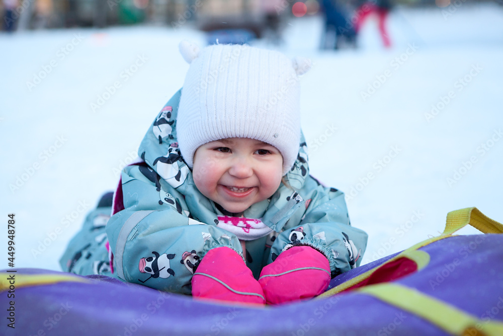 Smiling and laughing baby with snowing tube, portrait Smiling and laughing baby with snowing tube, portrait