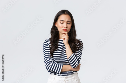 Lifestyle, people emotions and casual concept. Thoughtful troubled businesswoman thinking. Girl searching solution looking down pondering, making difficult choice photo