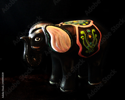 Elefante negro de cerámica decorado con vivos colores, para usar de alcancía