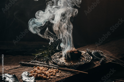 Charcoal burning with incense, incense resin, rosemary, laurel, lavender on a rustic wooden table, 
smudge stick, smudging, energetic cleansing and smoking.Sahumar
